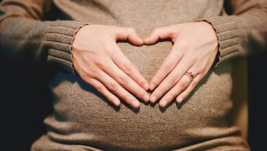 woman forming her hands as heart to his belly