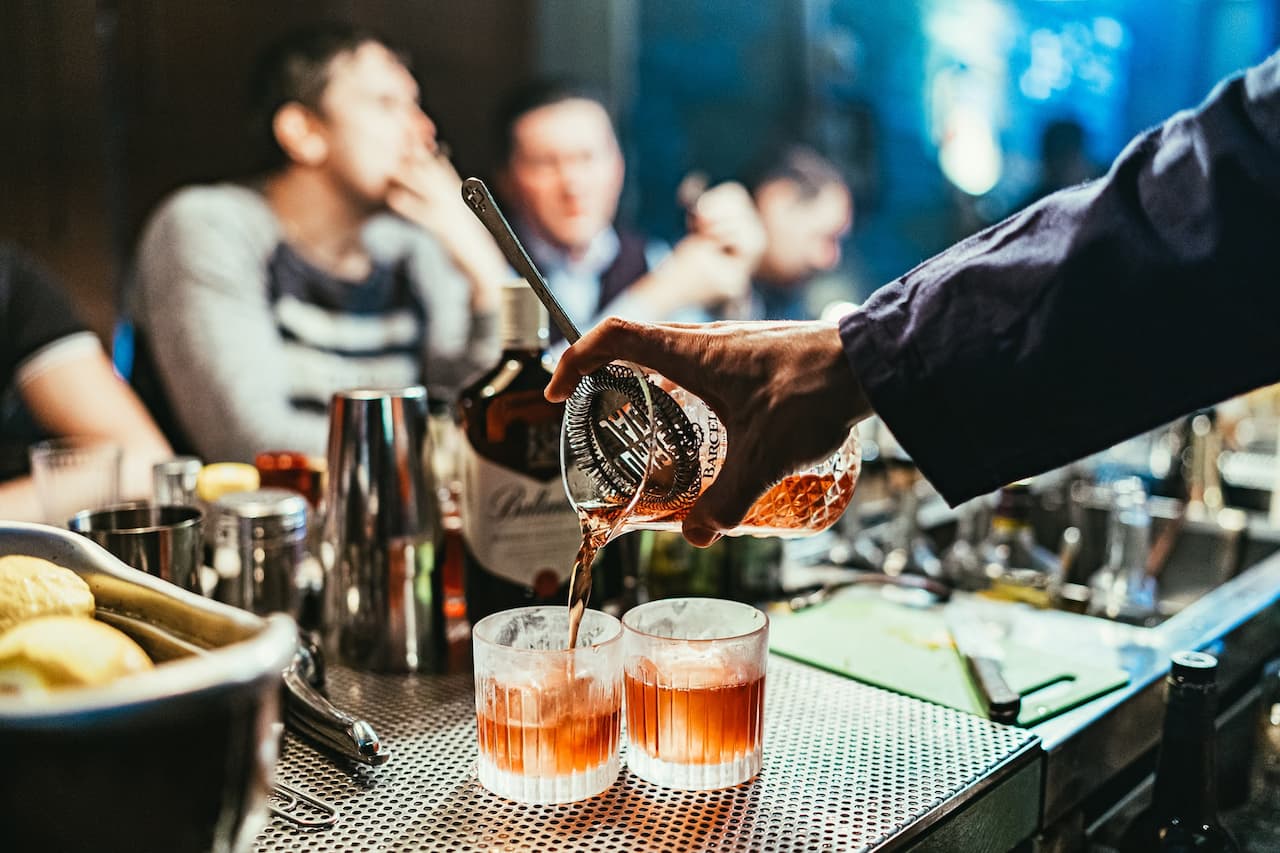 bartender pouring mixed alcoholic beverages