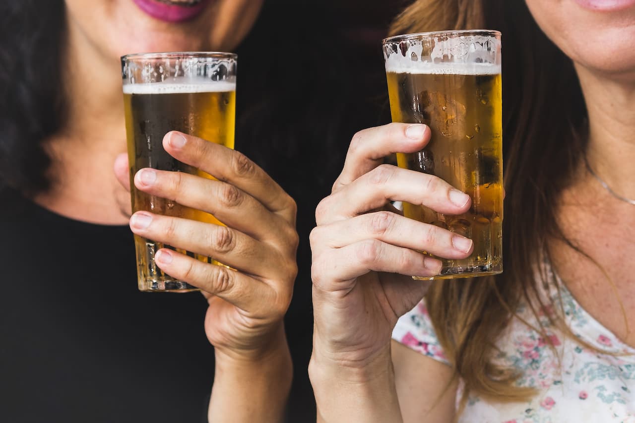 two women holding a glass of beer 